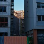 A modern construction site between two buildings in an urban setting.