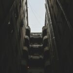 A moody urban scene showcasing towering buildings and strong vertical lines.