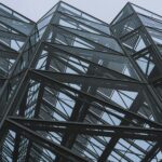 Dynamic perspective of a modern glass and steel building showing geometric patterns.